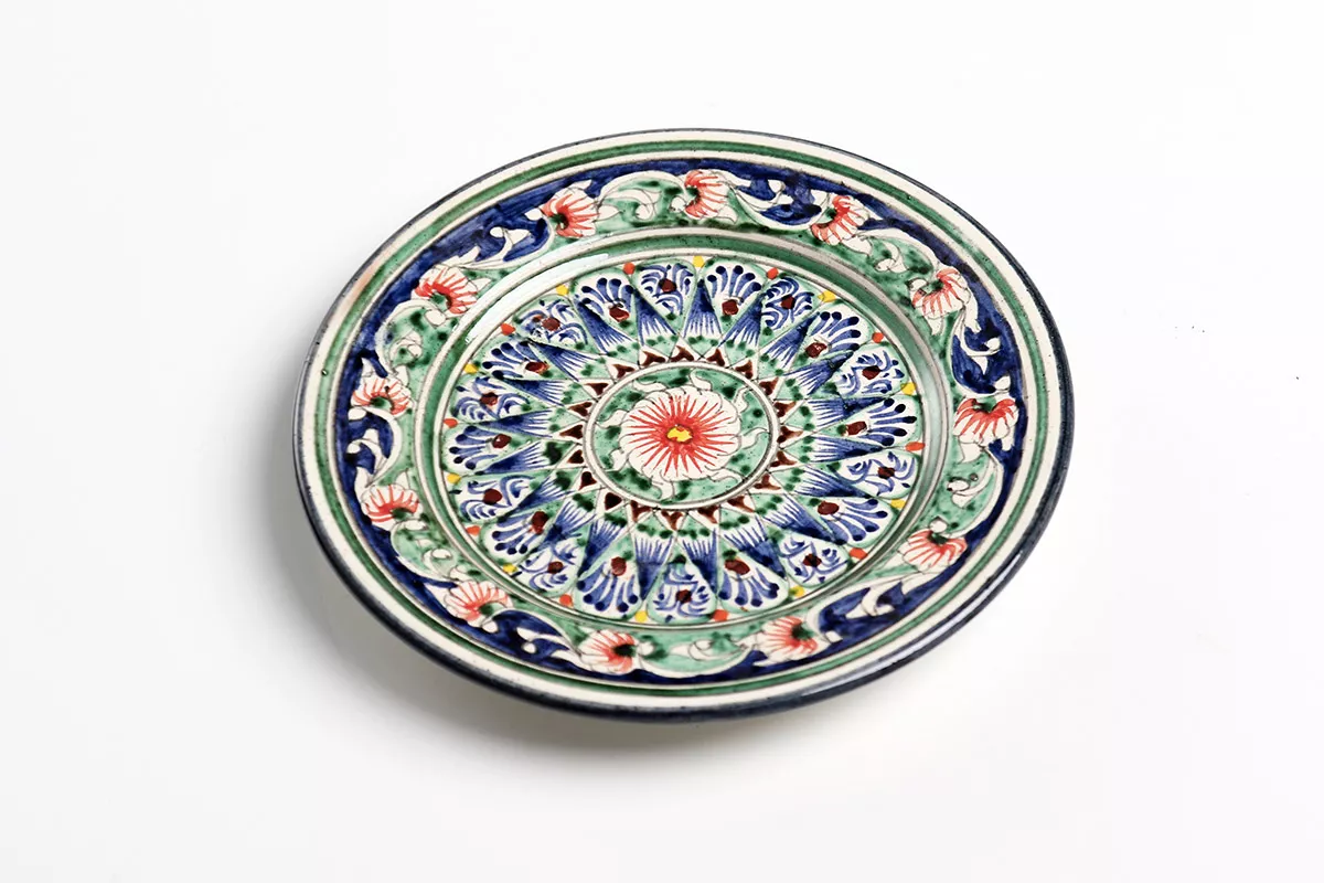 Glazed ceramic saucer with bright, intricate design